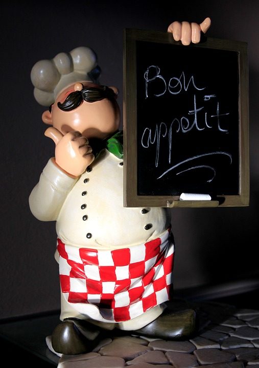 Kokfiguurtje met een Bon appetit-schoolbordje
